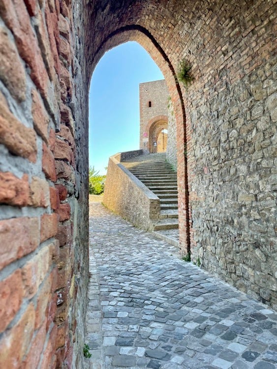 View of the Rocca of Montefiore from below and entrance to the castle. Below, the Rocca Malatestiana of Mondaino and the entrance to the Malatesta Pits.