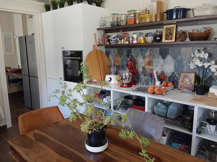 Kitchen with wooden table  and armchairs in the centre of the room.