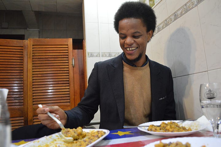 Mista Sanches reading a menu, decorations on the wall  at Tabarina, and Mista Sanches enjoying vegetarian cachupa 