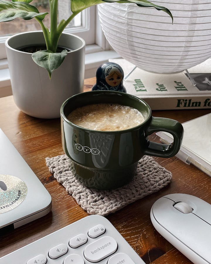 Image 1: Close-up of my coffee sitting on my desk. / Image 2: Close-up of my notebook and glasses resting on the wooden surface.