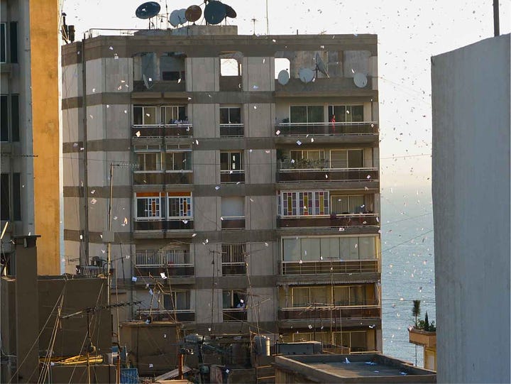 View from roof of Mayflower Hotel in Beirut of leaflets falling in Hamra during 2006 Lebanon War depicting Hezbollah building a castle of sand