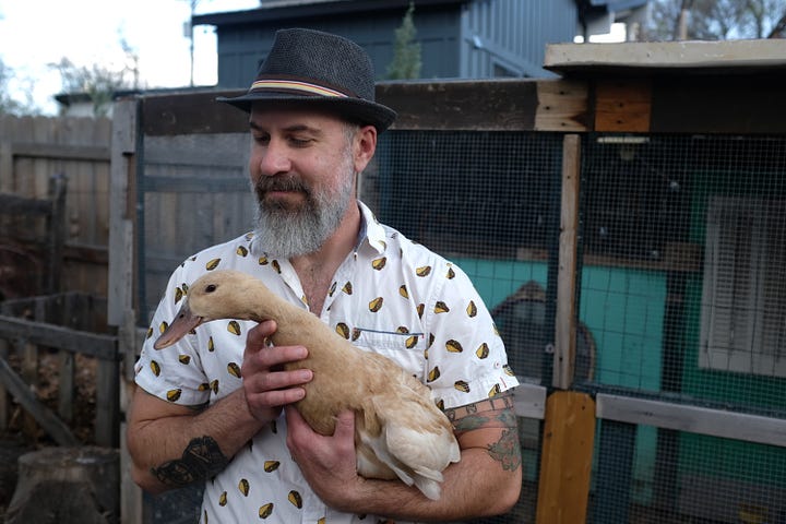 Matthew Schniper in his backyard with a duck.