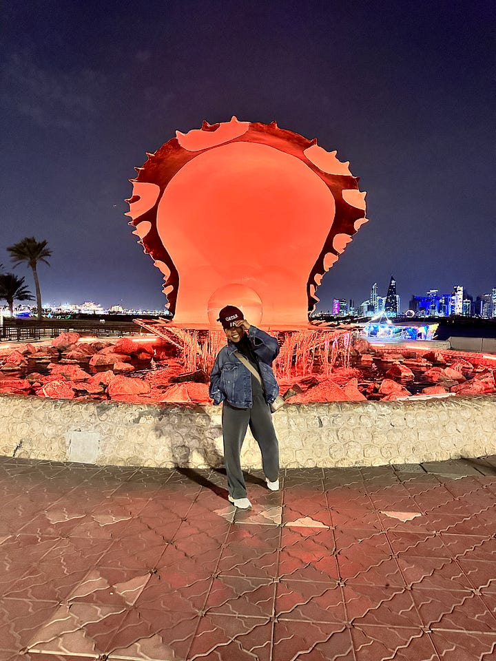 Woman posing in front of The Pearl, Doha Qatar