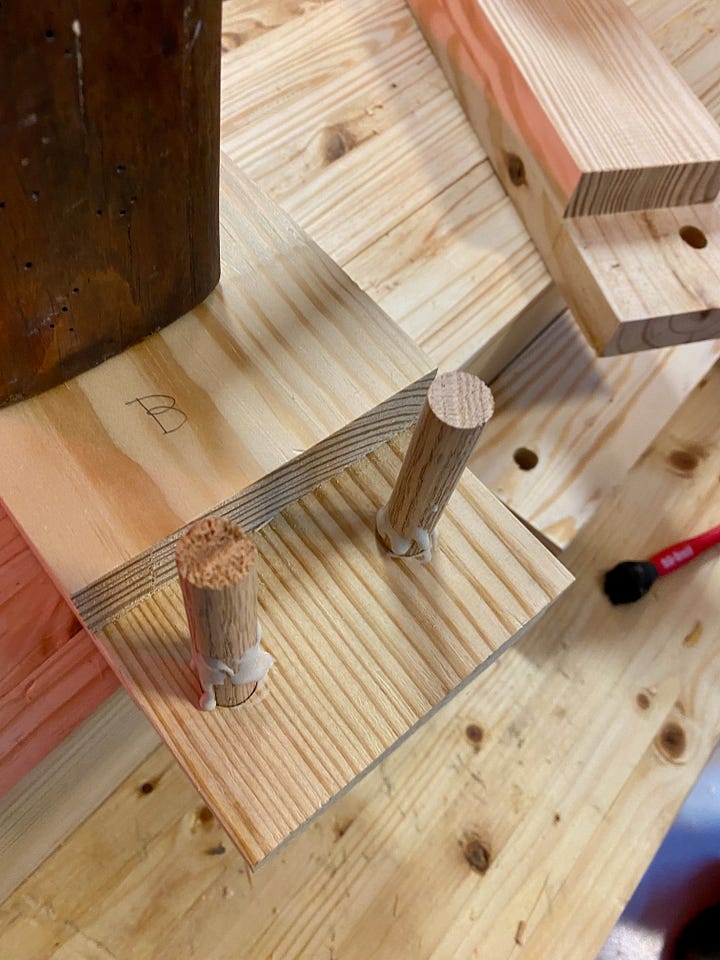 Drilling holes in the side of a workbench top, then filling holes with dowels and making new holes.