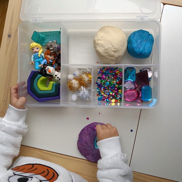 a 3 year old girl plays with a Frozen inspired playdough box