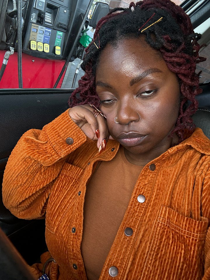 a black femme inrust/burnt orange sits in a car at the gas station. in the first image she pouts. in the second her eyes roll in agony.