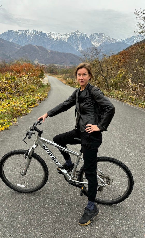 A snow monkey on a bridge and the author on her bicycle in the mountains