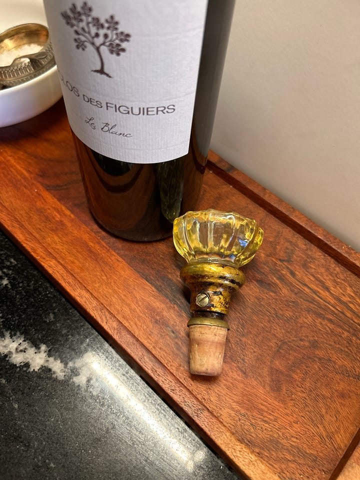 Karen Bussen holds a bottle of Beaujolais while posing for a selfie with Franck Chavy. Details from a wine expo in Paris, and a wine stopper made from an old doorknob