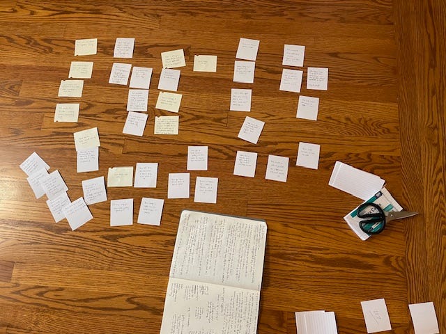 A notebook and small notecards in a pile on the floor, and then two images of the notecards arranged in a neat order across the floor