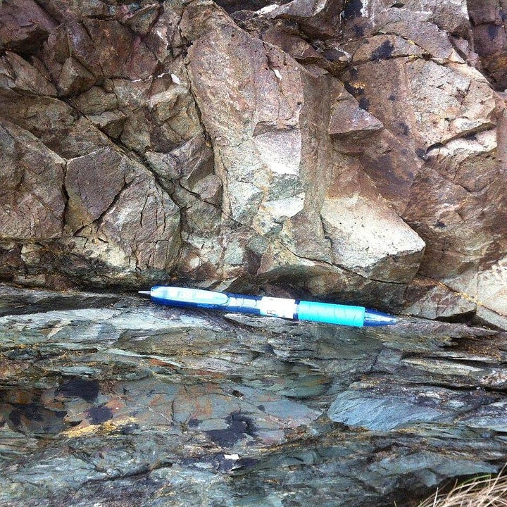 First image: outcrop of tan-colored rock on top of grey-colored rock. The boundary between the two is marked by a pen. Second image: a piece of white coral surrounded by black and red volcanic debris. A pen is included for scale.