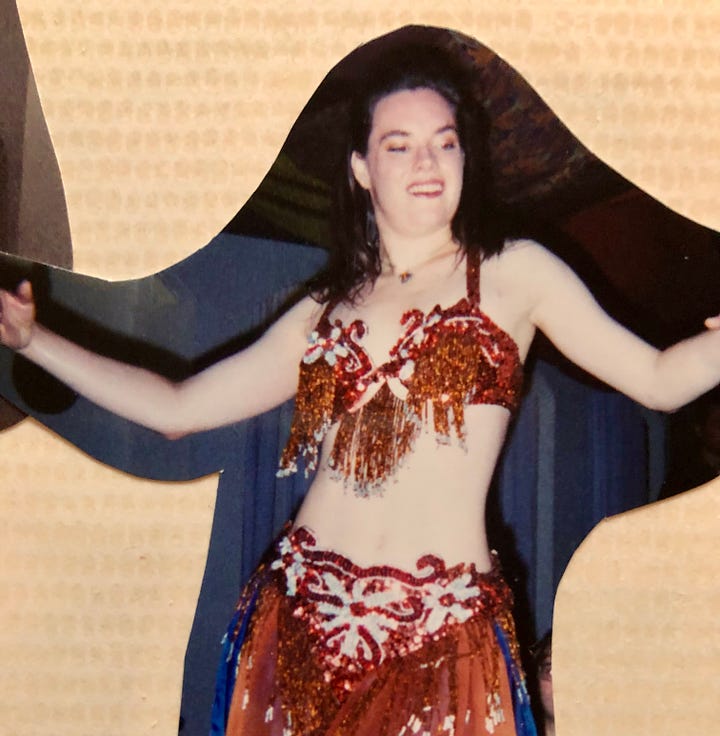 The author belly dancing in spangly costumes, one copper, and one turquoise.