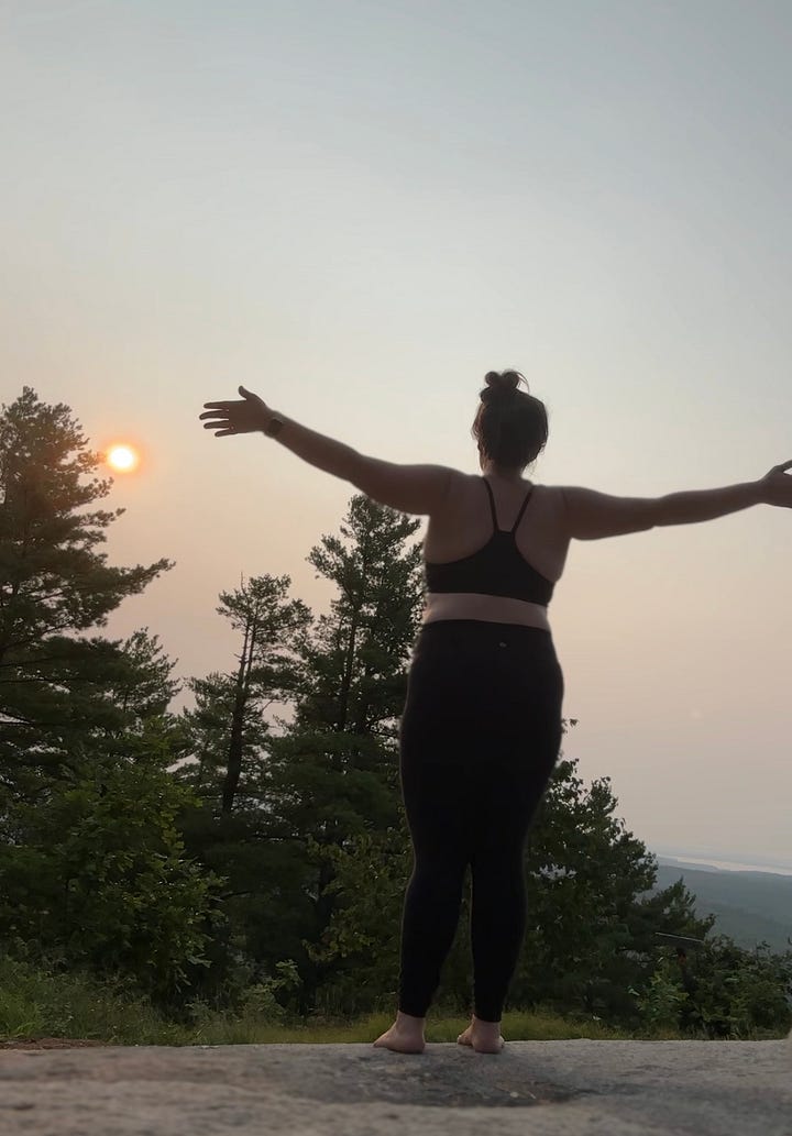 A gallery of images shows a woman standing on a mountain top with the rising sun in the background doing a series of yoga poses.