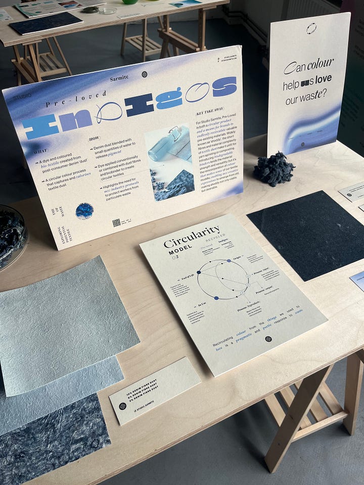 1-2. Exhibition table showing research artefacts for 'pre-loved indigos' from Studio Sarmite, including textile waste fibre, dye pigment, non-woven fabric sheets and information boards.