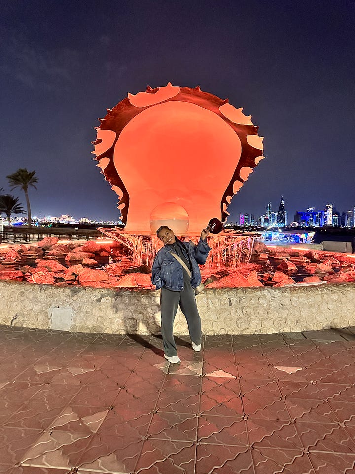 Woman posing in front of The Pearl, Doha Qatar