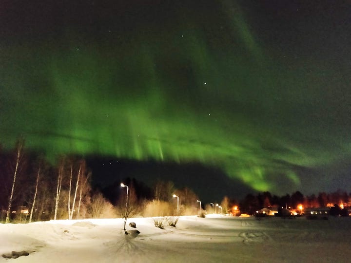 An image of green-hued Northern lights in a dark sky