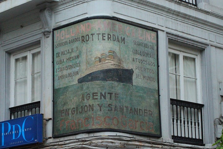 Hand-painted sign on a curved corner wall with lettering and a picture of a boat illustration.