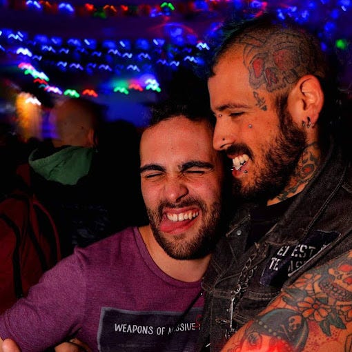 A vintage bike hangs on the walls of the neon -lit patio while two punk tatooed scruffy boys embrace at Feliza Gay & Lesbian Club in Buenos Aires