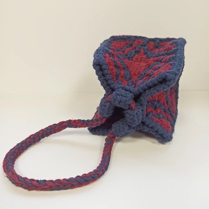 Small Komekuburo style pouch made in overlay mosaic crochet in burgundy and navy-blue.