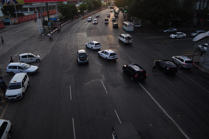 Images of cars on a main road and an old building in Yangon