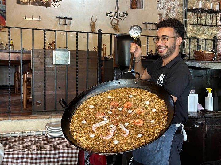 Large paella served to group in historic restaurant.