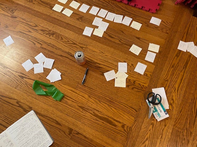 A notebook and small notecards in a pile on the floor, and then two images of the notecards arranged in a neat order across the floor