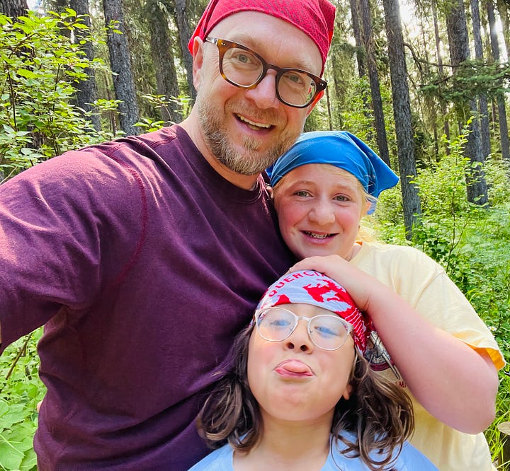 father with daughters wearing bandannas, boy picking huckleberries