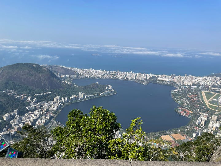 1. Christ the Redeemer from below. 2. The view of the ocean from atop a hill. 3. A trail marker painted on a rock (a yellow bootprint in a black arrow). 4. A close-up of a cool junction in a tree trunk.