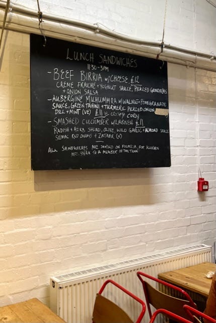 Dusty Knuckle sandwiches and menu with the sandwich ingredients including aubergine Muhammara, green tahini, pickled red onion, dill and mint
