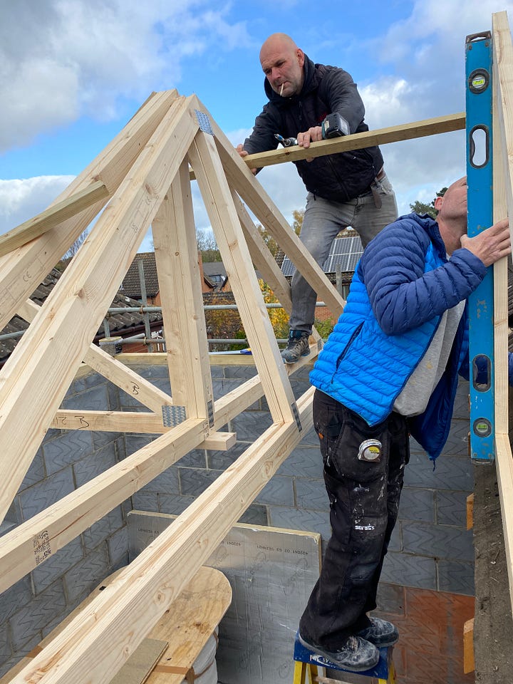 builders positioning the wooden roof trusses 