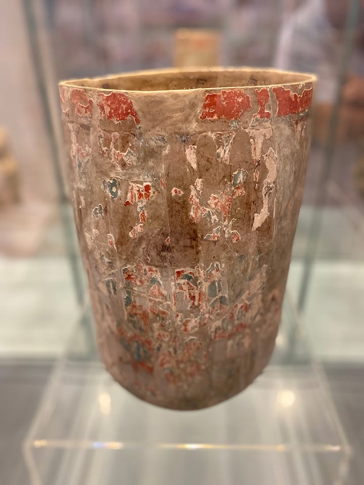 Ancient Mayan artifacts at the Museo Regional de Yucatán, Mérida. Clockwise from top left: A mural from Ek Balam. Statue of a female ruler, with our guide Alfonso. A cylinder vase. Man's head with headdress, Ek Balam.