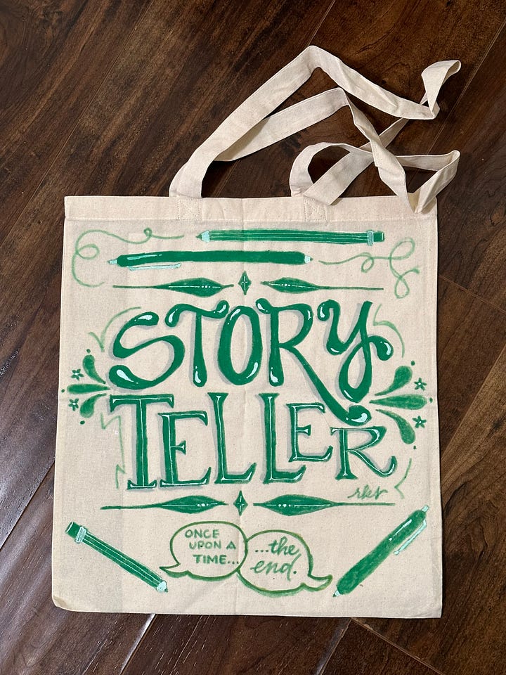 Left: a tote bag with "writer writer writer" hand lettered in purple acrylic paint and adorned with pens and pencils and other doodles; right: a tote which reads "storyteller" hand lettered in green acrylic paint and adorned with pencils, pens and two speech bubbles that read "once upon a time" and "the end"