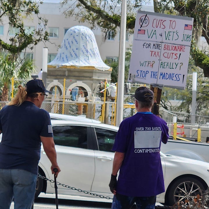 Veterans holding signs in protest of President Trump