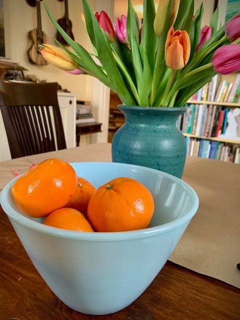 two photos, a bowl of oranges and vase of tulips, and a watercolor of the bowl of oranges