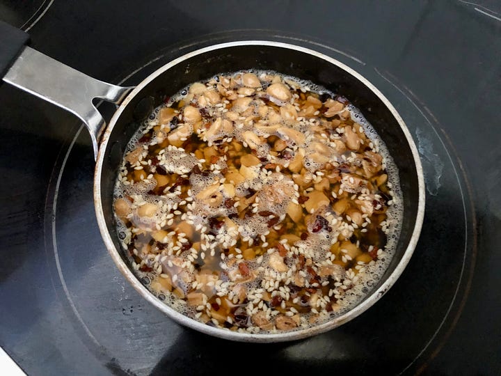 A small saucepan with peanuts and oil, plus a chicken salad