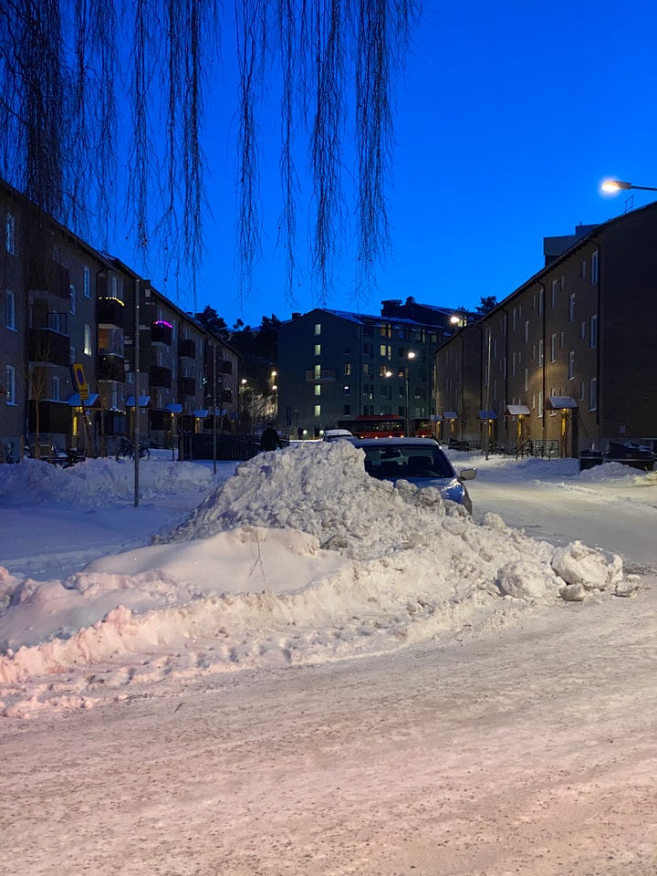 The streets in Stockholm piled with snow at dusk