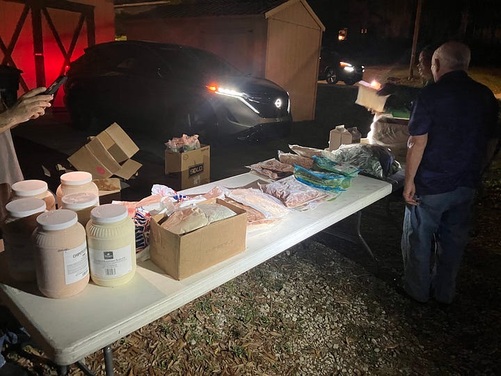 Jon Pantoja, Edward Hood, Daniel Paasch, and Ginni Stalker stand in front of their food distribution tables