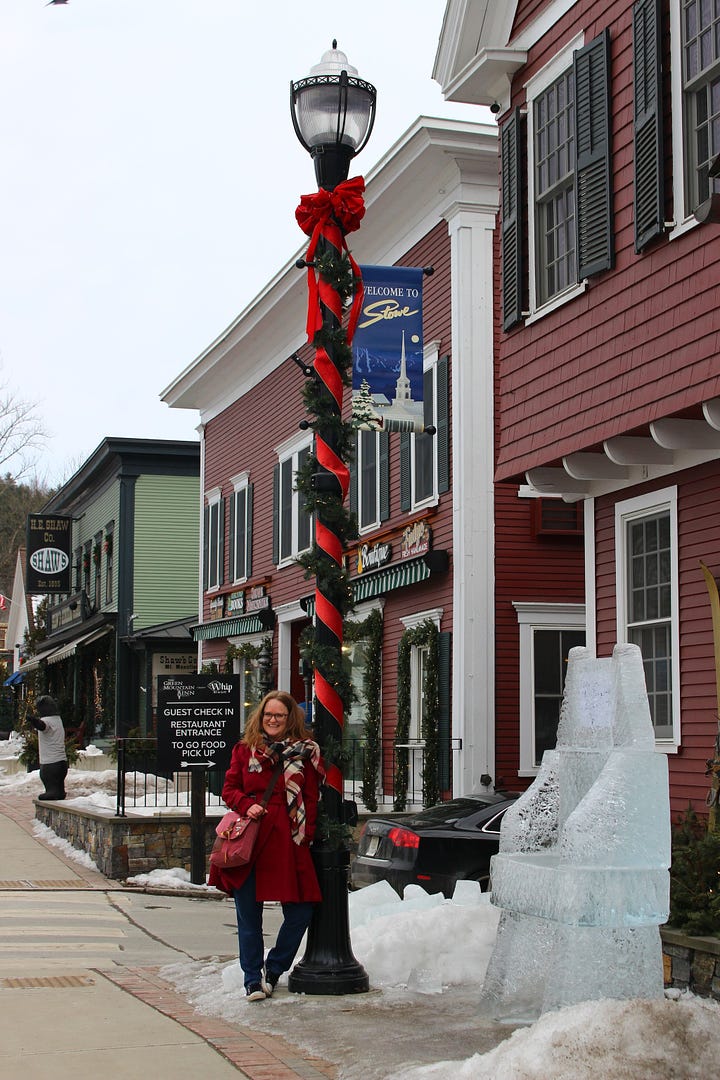 Amber, wearing a burgundy coat, (top L to bottom R) stands beside a sign for the Old Yard Cemetery, stands under a sign for the Green Mountain Inn, stands at the Stowe, Vermont covered-bridge style walkway, and stands beside a festive light post.