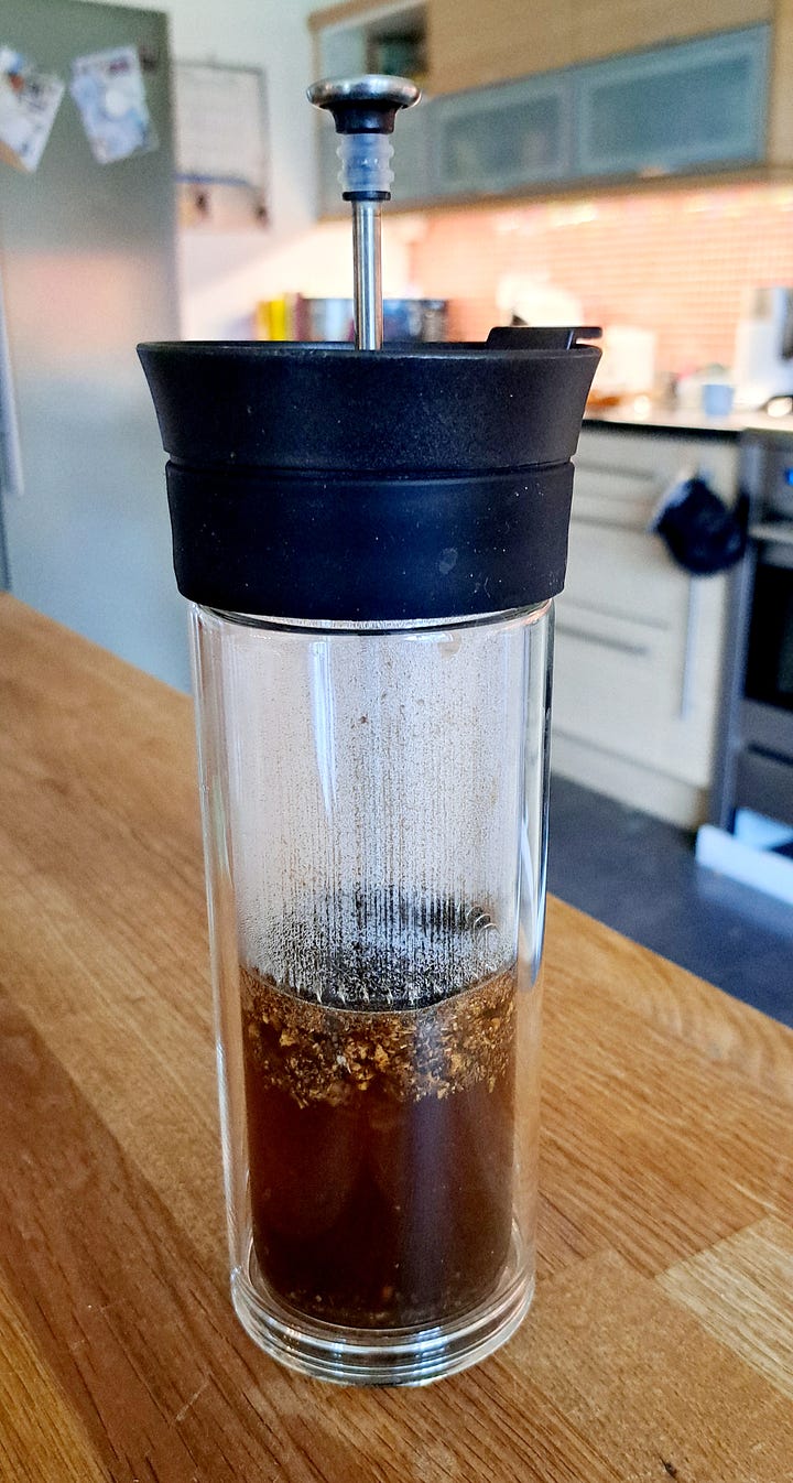 1. Chopped and roasted chunks of root on a plate. 2. Ground into a fine brown powder. 3. Brewing in a glass cafetiere. 4. Dark brown dandelion coffee in a white cup.