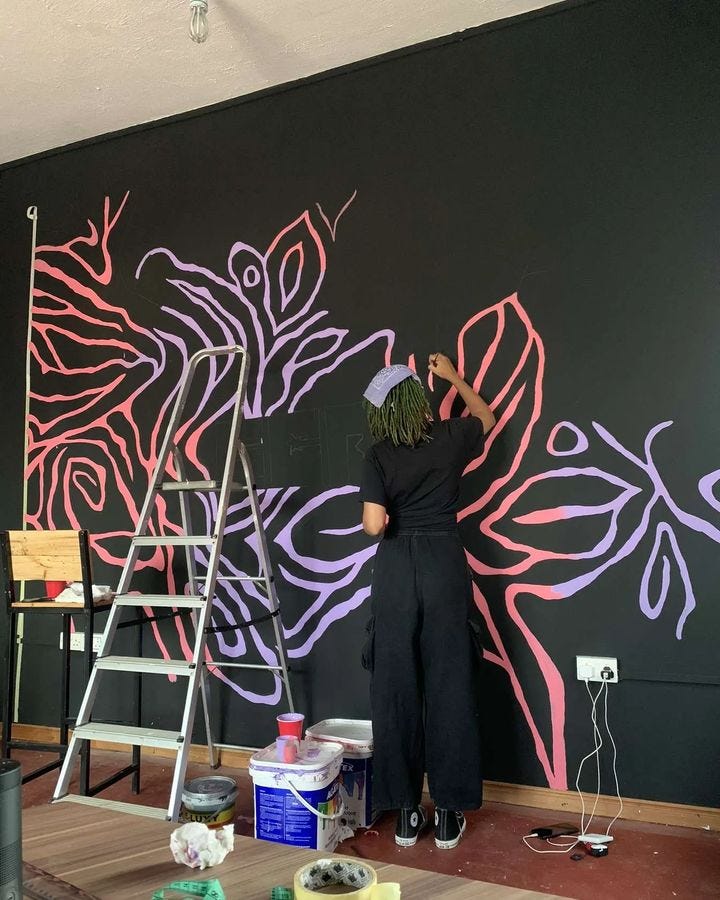 Viola painting a mural for the Gold Coast Report Office, Osu
