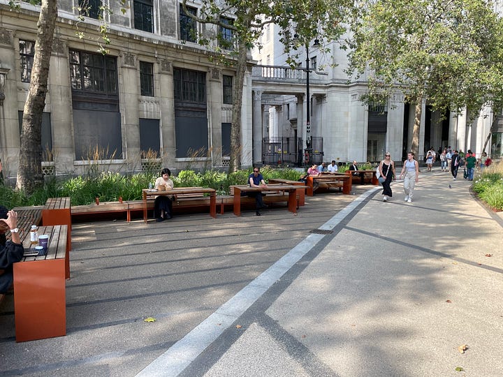 Pictures of the Strand Aldwych scheme. Many of the pictures are of pedestrian spaces, with extensive planting throughout and trees. People are walking in the street, and sitting at provided benches. There is one picture with someone on a bicycle, and another picture with my outside the disused Strand station