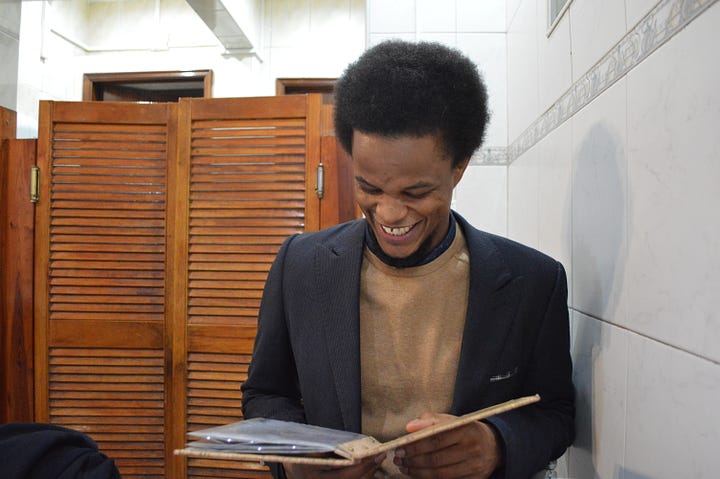 Mista Sanches reading a menu, decorations on the wall  at Tabarina, and Mista Sanches enjoying vegetarian cachupa 