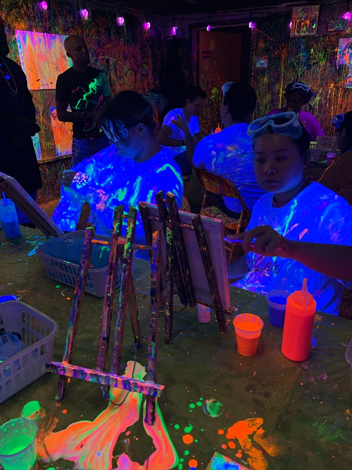 Graduate students paint their canvases and themselves with psychedelic neon paint