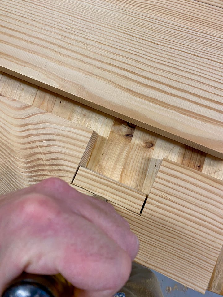 Chiseling a notch in a leg, gluing and clamping a leg, and then cutting a second notch with a chisel.