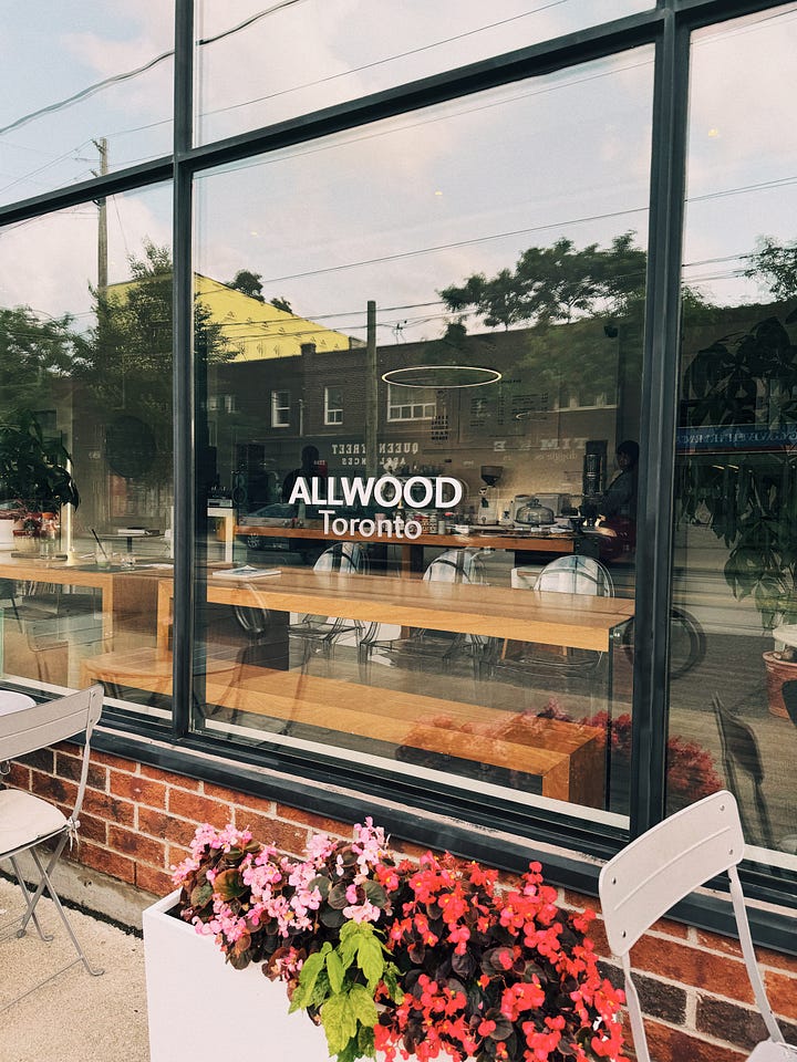 Two pictures of the exterior of a cafe. First picture is a window with the name Allwood Toronto on it. Second picture is the brick exterior.