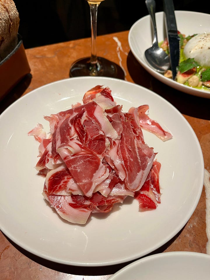 a dinner of shrimp and pasta, a plate of jamón