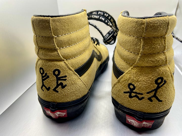 the front and back view of a pair of yellow suede Vans sneakers (a collaboration with A Tribe Called Quest).