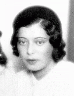 Left: Woman with dark hair wearing a white shirt. Right woman with dark hair wearing a white dress with a black collar.
