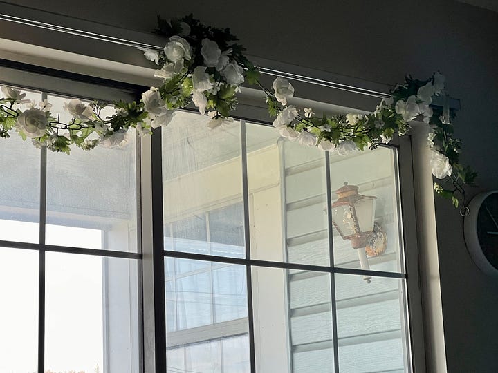On the left side, there is a photo of a glass sliding door leading to the balcony, with a garland of white flowers and green leaves above it. On the right side, there is a photo of a titmouse on a branch in a tree.
