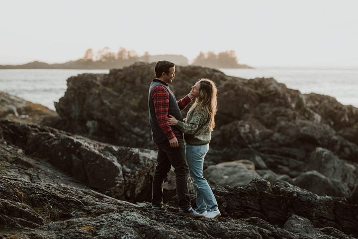 Beach front Tofino arranged photo shoot A couple posing on the rock, Videographer Brittany Ballamy running in the sand, surfer Emily Ballard sitting on the beach and a women in Reclamation company dress posing on rocks over looking the water 