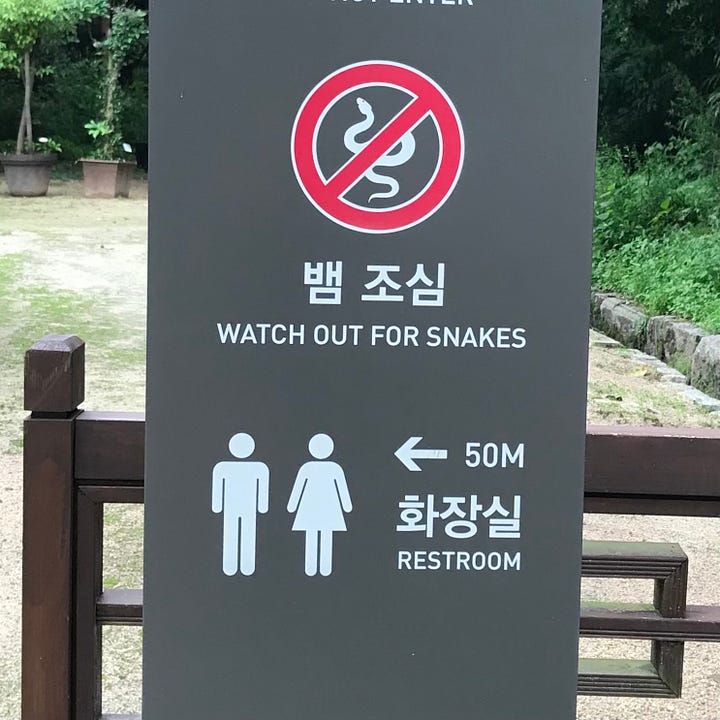 Sign warning for snakes. A stall with Korean lettering that sells candy.